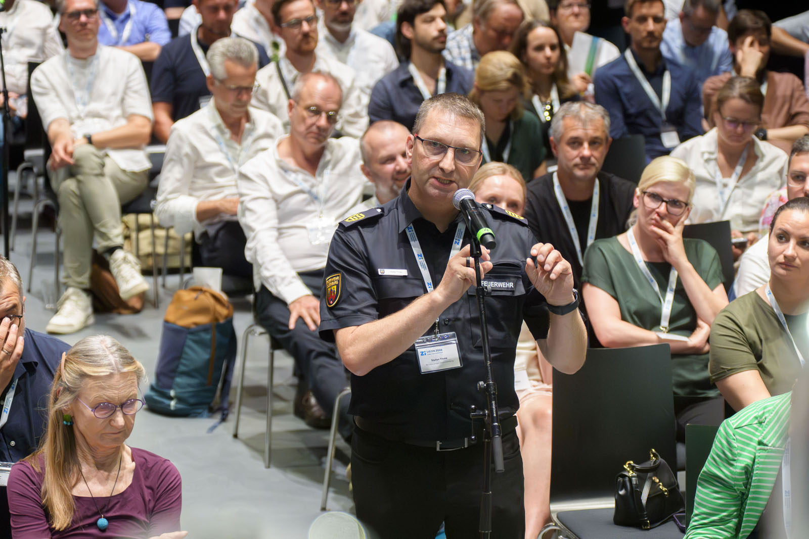 Vertreter der Feuerwehr stellt Rückfrage aus dem Publikum.