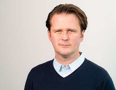 Dr. med. Sebastian Brokat Das Bild zeigt Dr. Sebastian Brokat, einen Mann mit dunkelblonden Haaren und einem dunkelblauen Pullover